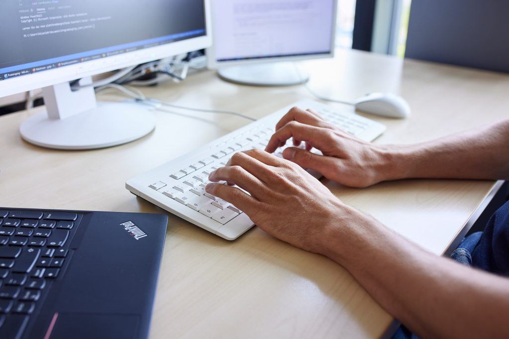 Mensch tippt auf der Laptop-Tastatur