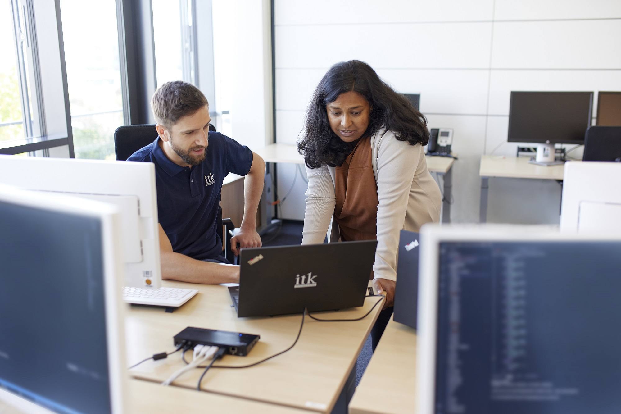 2 ITK Mitarbeiter arbeiten gemeinsam am Laptop