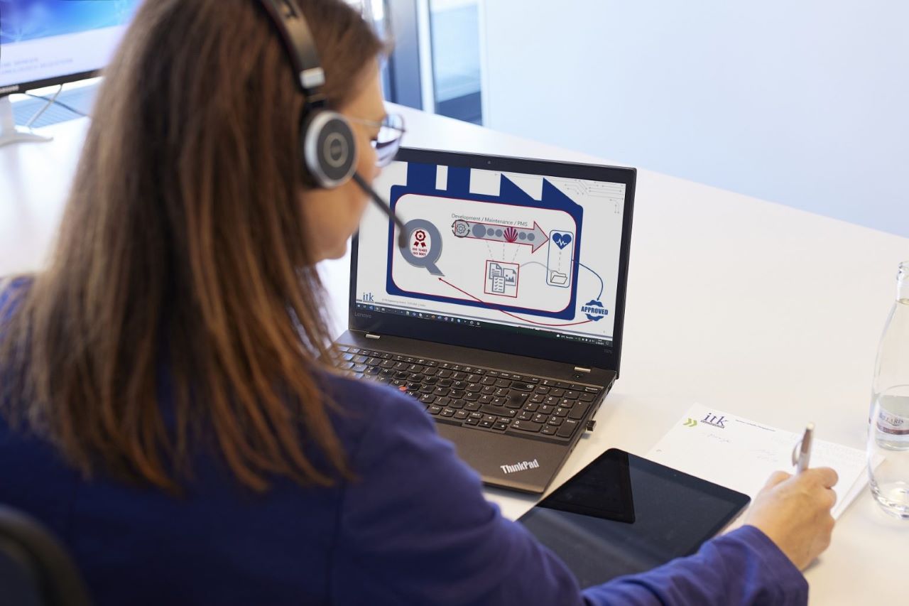 Woman with headset looking into a laptop