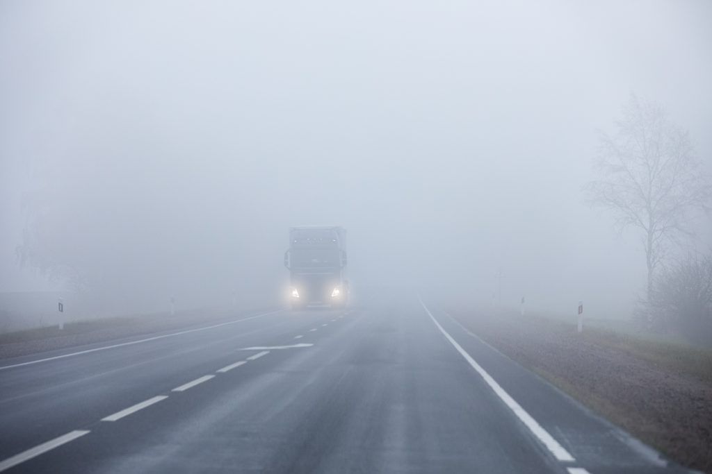 LKW fährt auf einer nebligen Autobahn