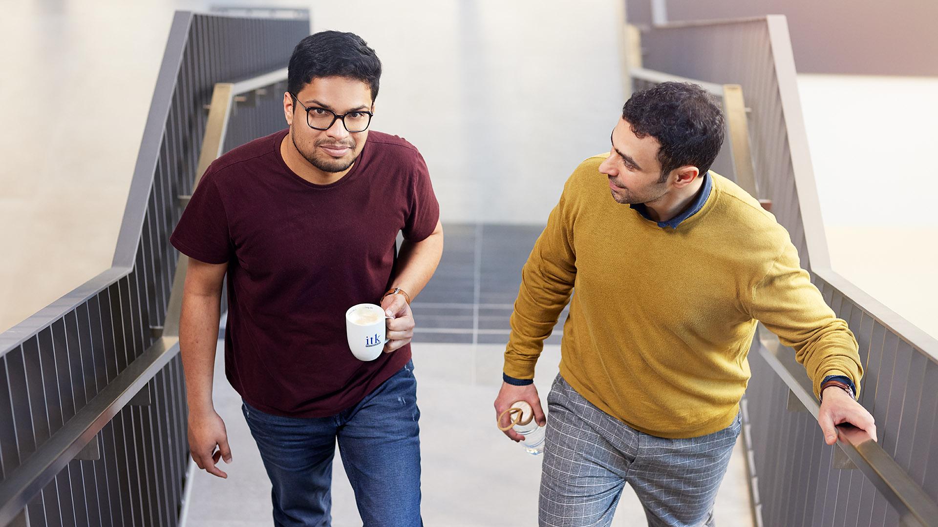 Two experienced ITK employees walking up the stairs
