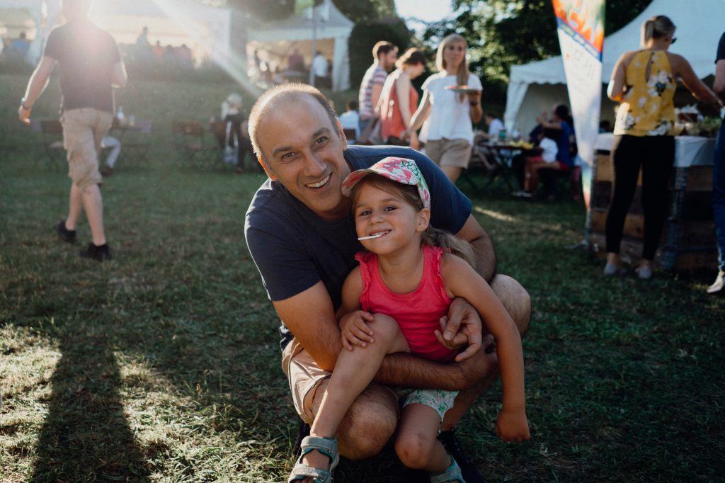 A father with his little daughter at a company party, smiling for a photo
