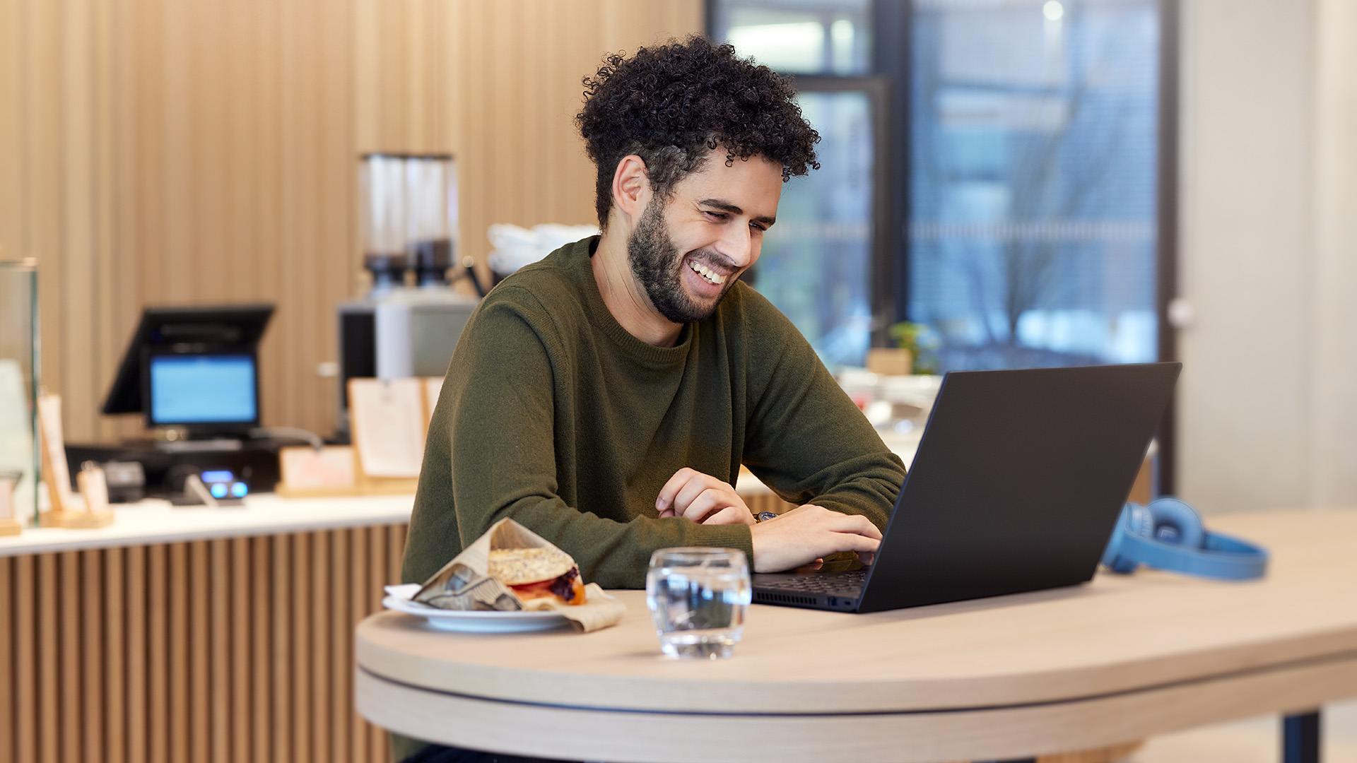 Ein lächelnder ITK Mitarbeiter am Laptop.