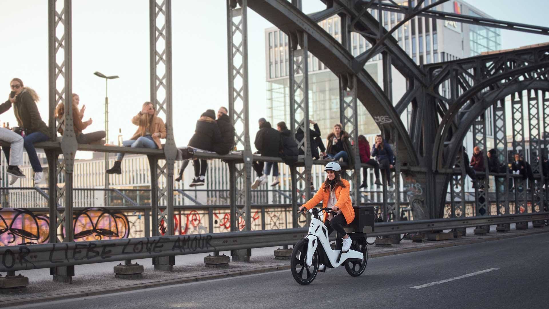 A woman rides her e-bike smoothly across the Hackerbrücke in Munich.