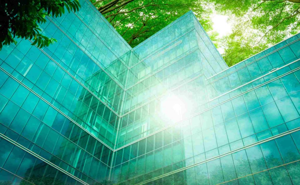 Ein Glasgebäude mit Spiegelungen grüner Bäume – ITK unterstützt die Entwicklung innovativer Produkte und datenbasierter Services in der Climate-Tech-Branche.
