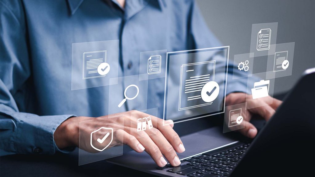 Training participant at laptop with safety symbols in foreground.