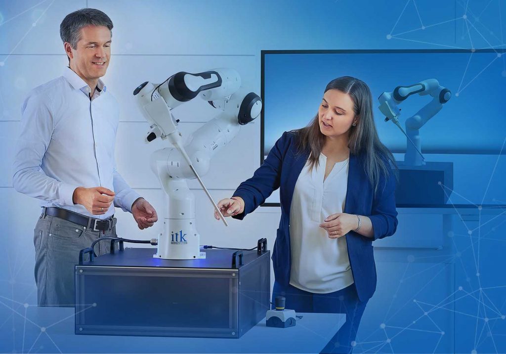 Robotic arm with two engineers in front of a digital twin.