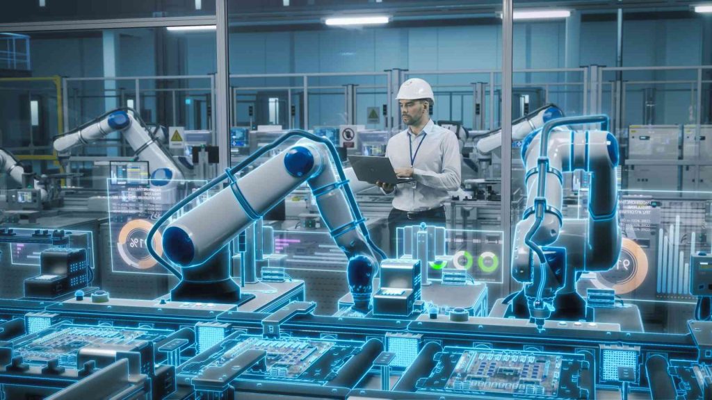 Ein Mann mit einem Schutzhelm steht vor einem Roboter in einer industriellen, automatisierten Umgebung.